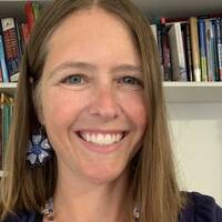 Kimberly Martin smiling in front of a bookshelf